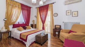 A bedroom with a bed, a chest of drawers, a small table, a chair, and a radiator. - Amalia Country House (Zakynthos)