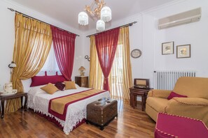 A bedroom with a bed, a chest of drawers, a small table, a chair, and a radiator. - Amalia Country House (Zakynthos)