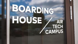 Ikkunassa on teksti: ”BOARDING HOUSE AIR TECH CAMPUS”, joka osoittaa paikan.