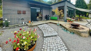 A modern house with a patio, garden, and outdoor seating area.