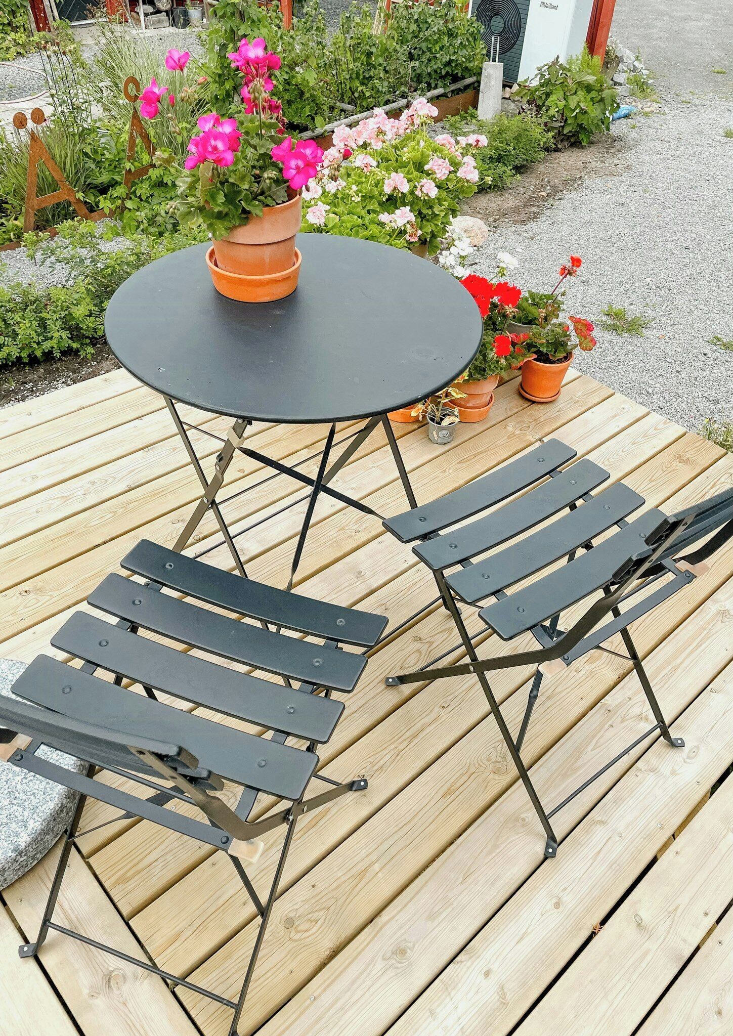 A wooden deck with a round table and four chairs.