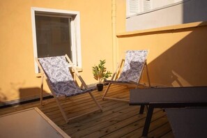 A balcony with two lounge chairs, a small table, and a potted plant. - SPA central charmant duplex cosy 90m2 à 300m rue piétonne et 500 m du port (Boulogne-sur-Mer)