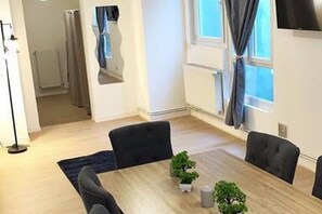 A modern room with a dining table, chairs, a small plant, and a window with curtains. - SPA central charmant duplex cosy 90m2 à 300m rue piétonne et 500 m du port (Boulogne-sur-Mer)