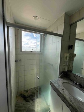 A bathroom with a glass shower enclosure, a window, a sink, and a mirror. - LK Barro Preto 10 (Belo Horizonte)