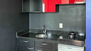 A compact kitchen with a sink, stove, and cabinets. - LK Barro Preto 10 (Belo Horizonte)