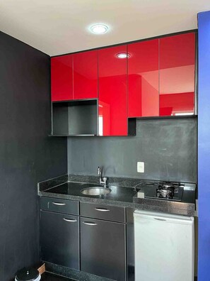 A compact kitchen with a sink, stove, and cabinets. - LK Barro Preto 10 (Belo Horizonte)