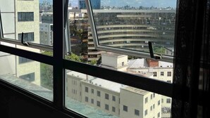 A view through a window with a clear sky and buildings in the distance. - LK Barro Preto 10 (Belo Horizonte)