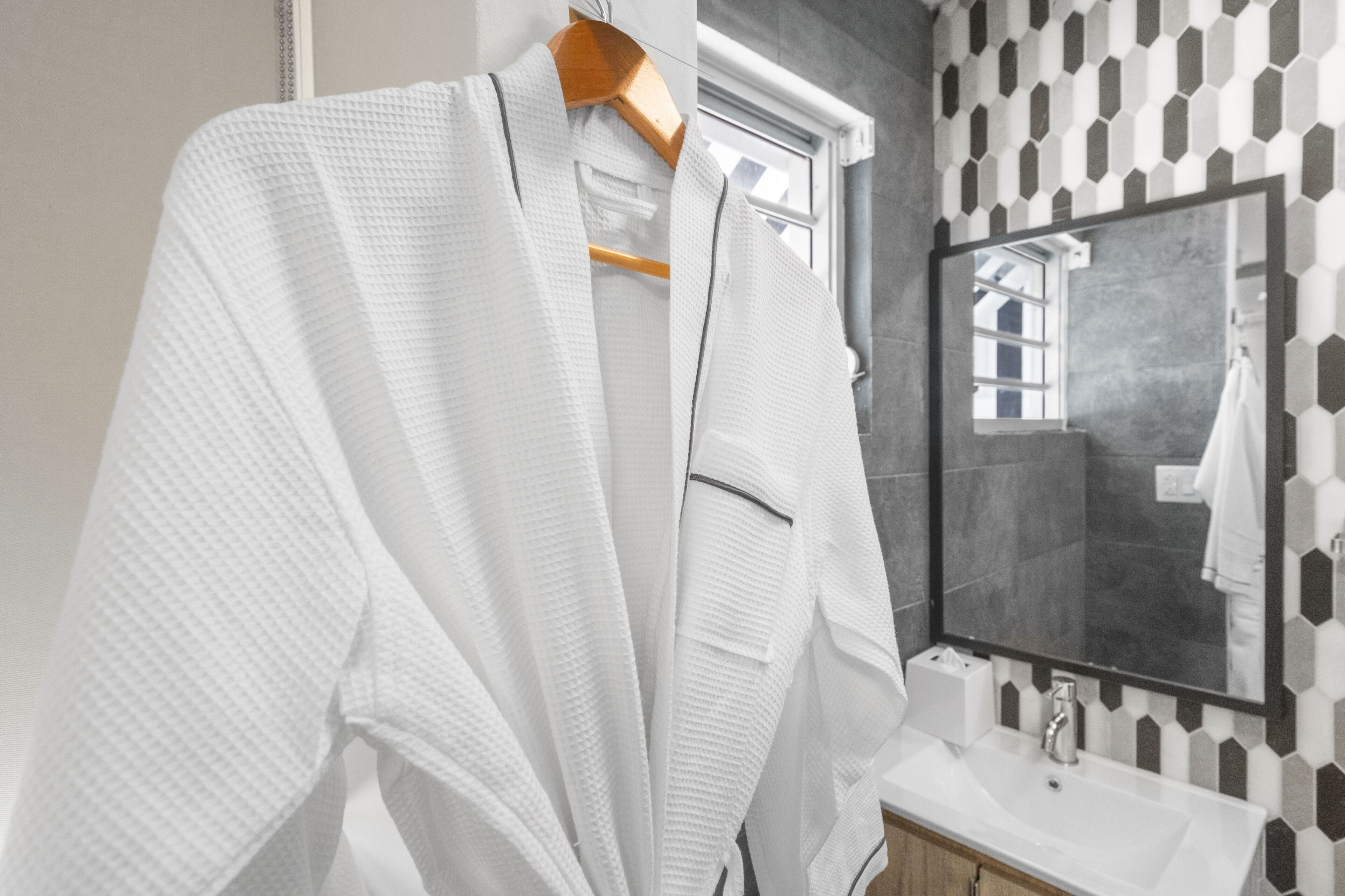 A bathroom with a white towel rack, a mirror, and a sink.