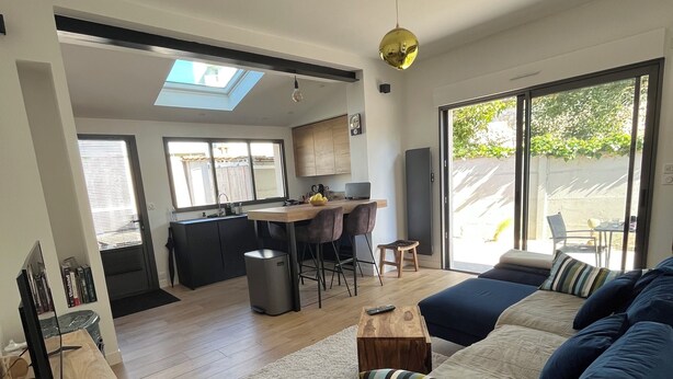 Una sala de estar moderna con un sofá, una mesa de centro y un mueble para televisión.