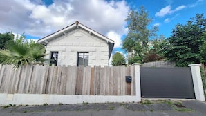 Una casa con cerca de madera, puerta de garaje y buzón.