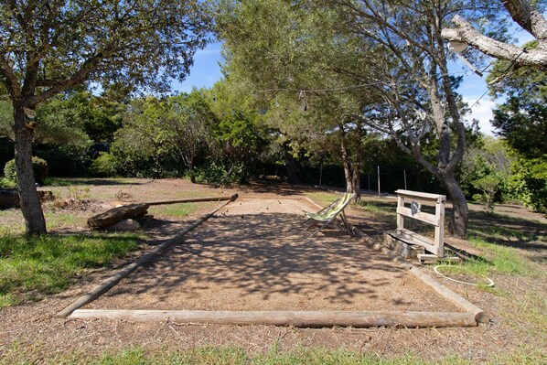 Un parco con una panchina di legno, un indicatore stradale e un sentiero sterrato.