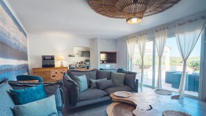 A modern living room with a sofa, coffee table, and kitchen in the background.