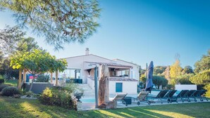 A house with a swimming pool, outdoor seating, and a garden.