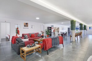 A spacious living area with a sofa set, a coffee table, and a dining table with chairs. - Apartment 'Alojamento Rio Neiva' with Mountain View, Wi-Fi and Air Conditioning (Tregosa)