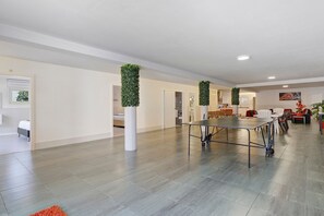 A spacious room with a long table, white pillars, and green vertical gardens. - Apartment 'Alojamento Rio Neiva' with Mountain View, Wi-Fi and Air Conditioning (Tregosa)