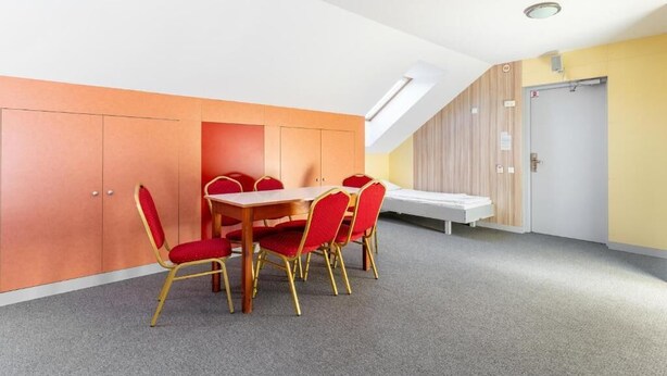A conference room with a table and chairs, a ceiling light, and a door.