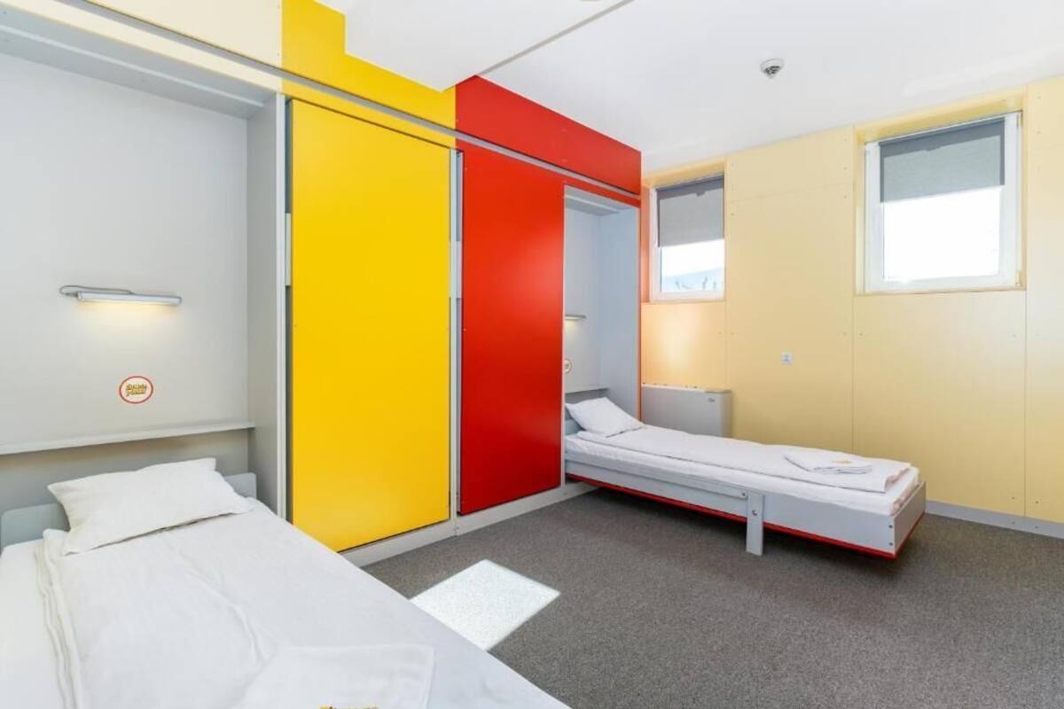 A room with a bed, a wardrobe, and a small bedside table.