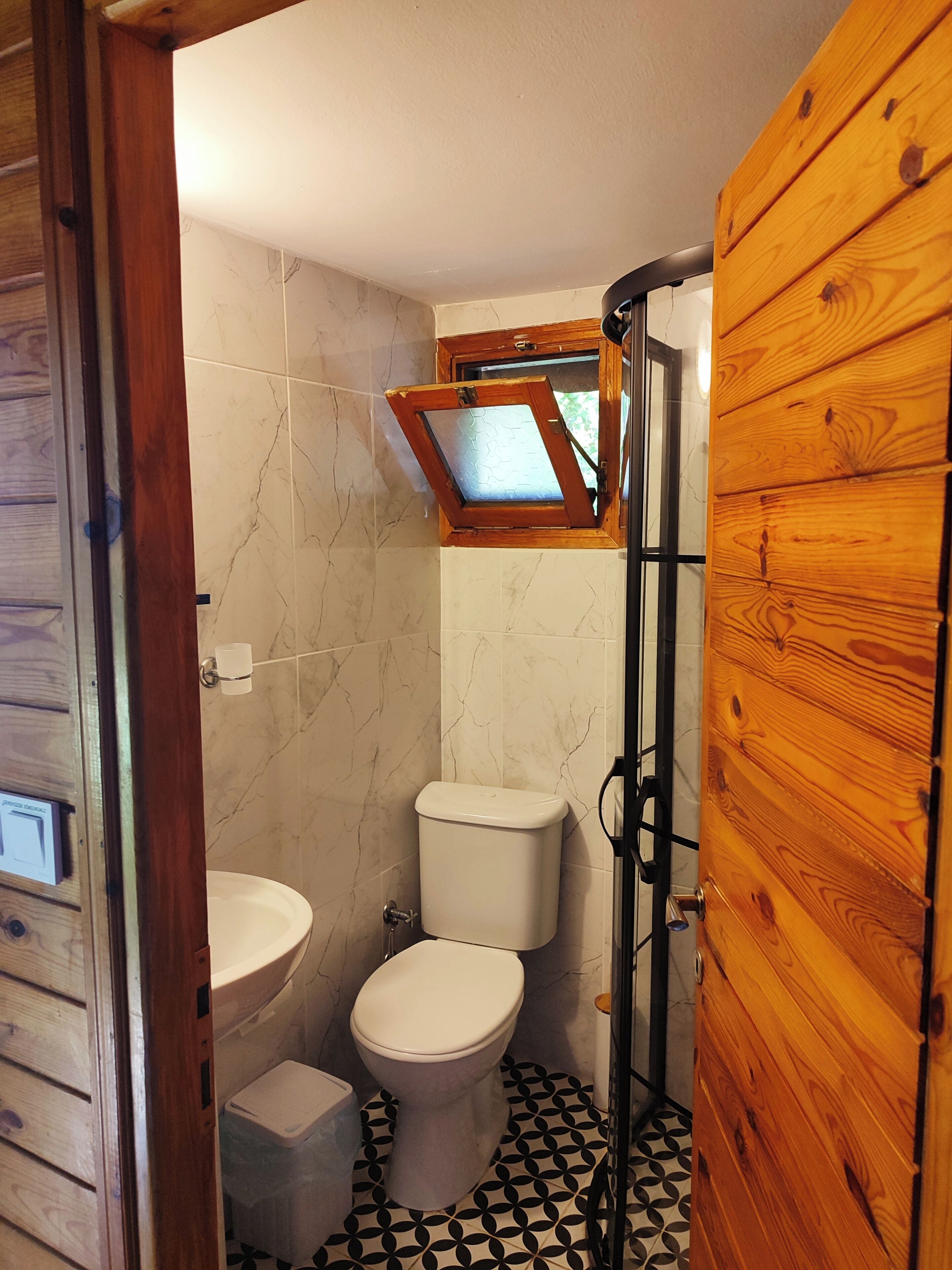 A bathroom with a toilet, sink, and shower.