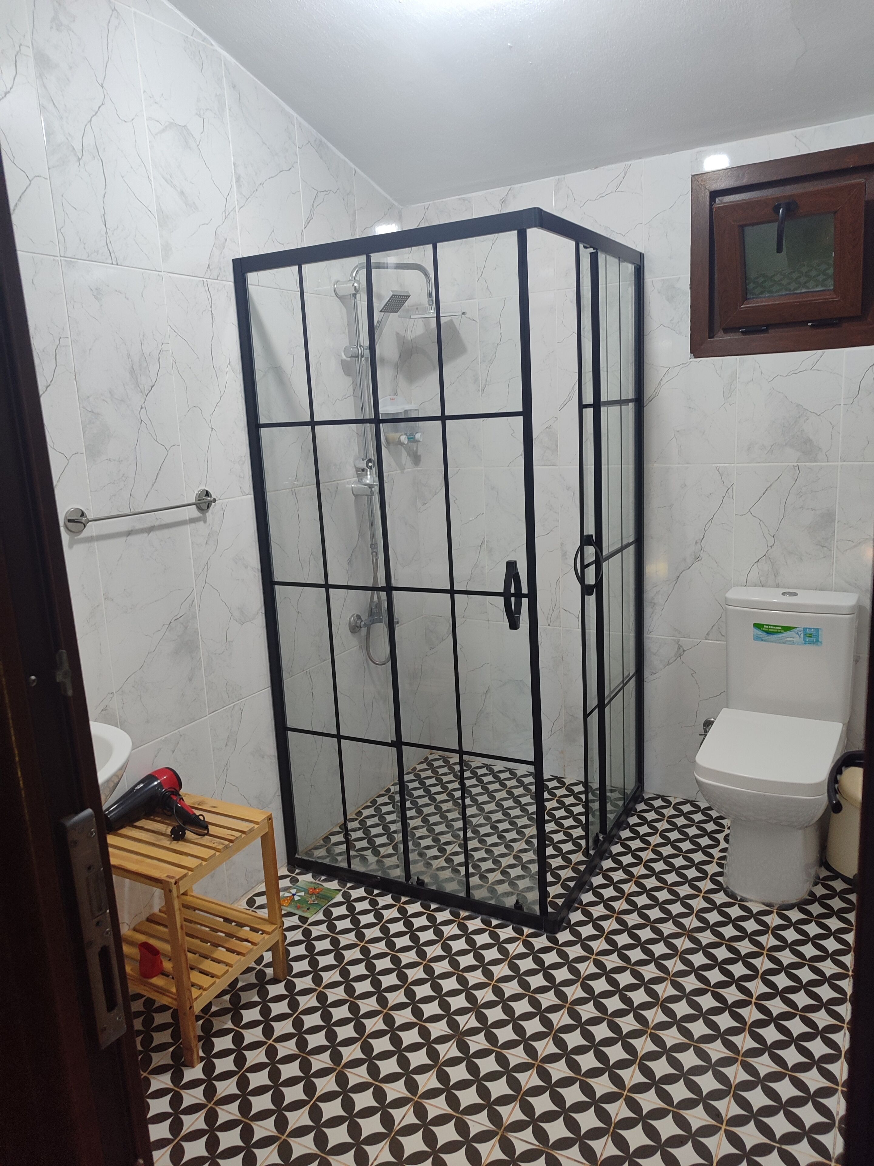 Een badkamer met een douchecabine, toilet en wastafel.