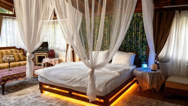 A bedroom with a canopy bed, a sofa, a small table, and a nightstand. - Agva Tartaruga Motel (Sile)