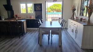 Una cocina moderna con una isla central, una mesa de comedor y vistas al exterior.