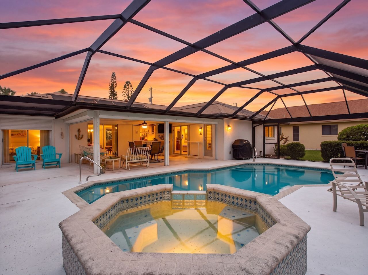 Ein Poolbereich mit Whirlpool, Liegestühlen und einer überdachten Terrasse.