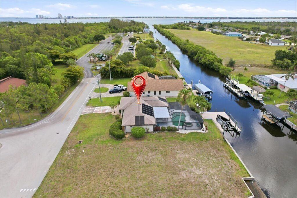 Aerial view of the waterfront home featuring a boat dock and screened pool enclosure.
