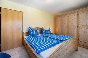 Una stanza con un letto di legno, un armadio e una credenza.