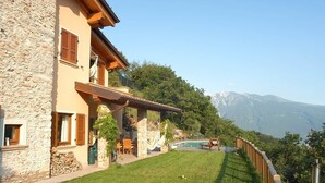 A stone building with a pool, outdoor seating, and a view of mountains. - Alone standing Rustico with pool, panoramic view 8 persons (Sermerio)