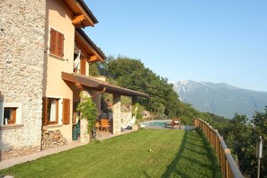 Ein Steinhaus mit Pool, Sitzgelegenheiten im Freien und Blick auf Berge.