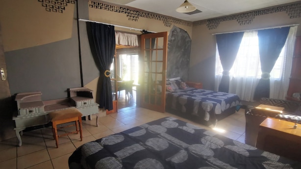 A room with two beds, a desk, a chair, and a piano.