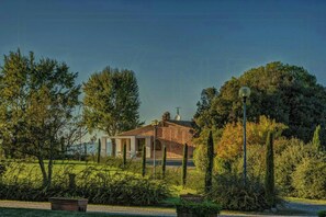 A house with a brick exterior, surrounded by greenery and a clear sky. - Panoramic villa with pool in Montaione (Montaione)
