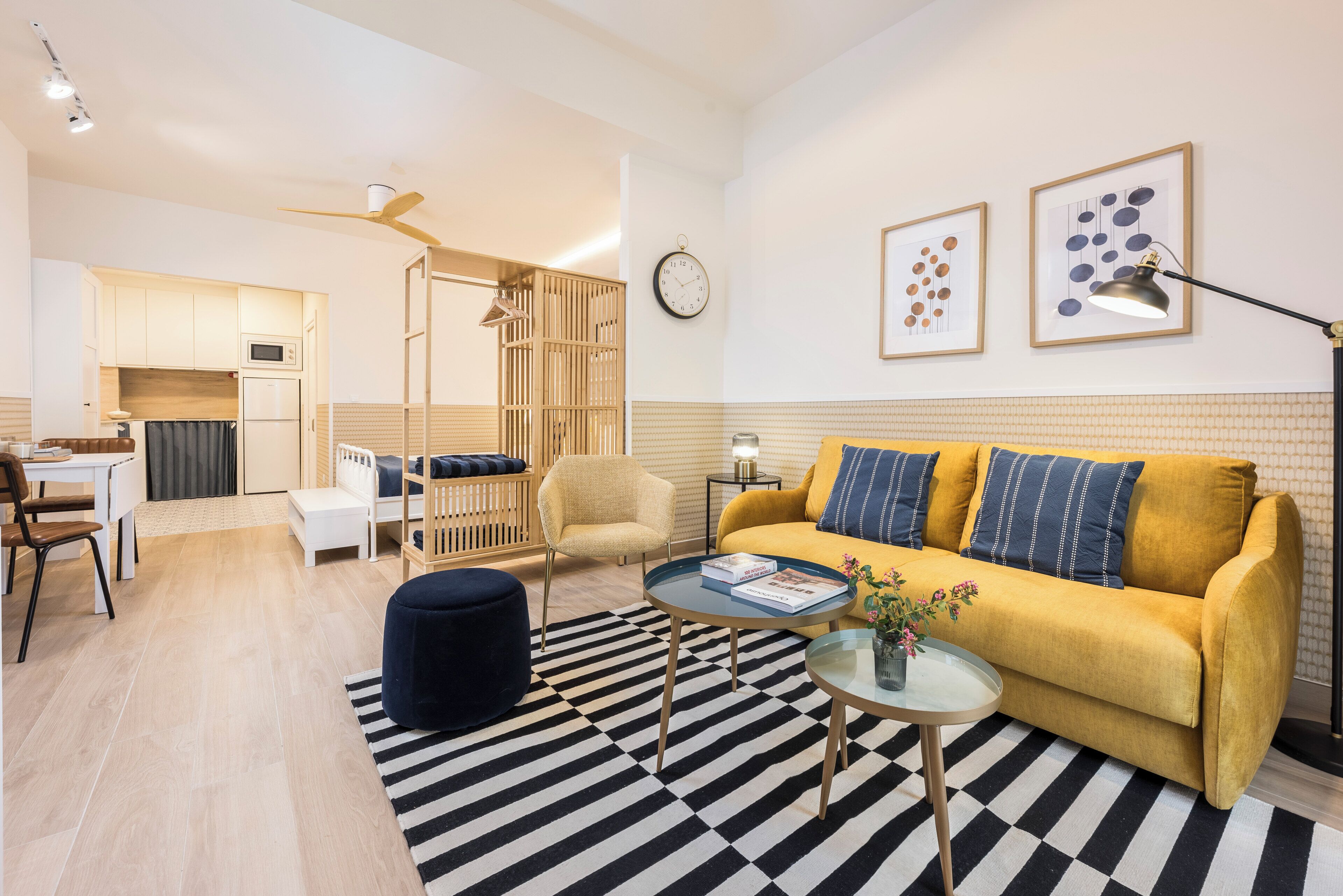 Una sala de estar moderna con un sofá, mesa de centro, reposapiés y un comedor con mesa y sillas.