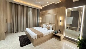 Une chambre d’hôtel moderne avec un grand lit, une table de chevet, un miroir et une plante en pot.