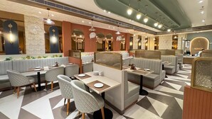 Un restaurant moderne avec des banquettes, des tables et un sol à motifs.