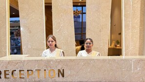 Un comptoir d’accueil avec un revêtement en marbre et le mot « RÉCEPTION » affiché en évidence.