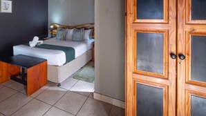 Un dormitorio con cama, mesita de noche y armario.