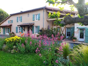 Une maison à deux étages avec un jardin à l’avant.