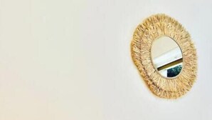A bed with white bedding, a round mirror with a textured frame, and a cylindrical lamp on a bedside table. - Hostdomus - Cozy corner near the sea (Finale Ligure)