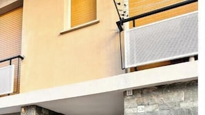 A building entrance with a stone facade, a metal gate, and a numbered sign. - Hostdomus - Cozy corner near the sea (Finale Ligure)