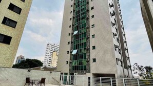 A high-rise building with a swimming pool and outdoor seating area. - LK Barro Preto 14 (Belo Horizonte)