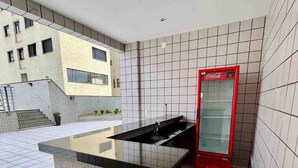 A modern kitchen with a black countertop and a red Coca-Cola refrigerator. - LK Barro Preto 14 (Belo Horizonte)