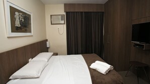 A hotel room with a bed, a TV, a painting on the wall, and a telephone. - LK Barro Preto 14 (Belo Horizonte)