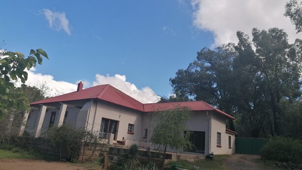 A two-story building with a red roof, surrounded by greenery and trees. - Room-bloekombos Guesthouse Family Unit (Kopanong)