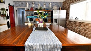 Cocina con encimera de madera, refrigerador y salpicadero con azulejos estampados.