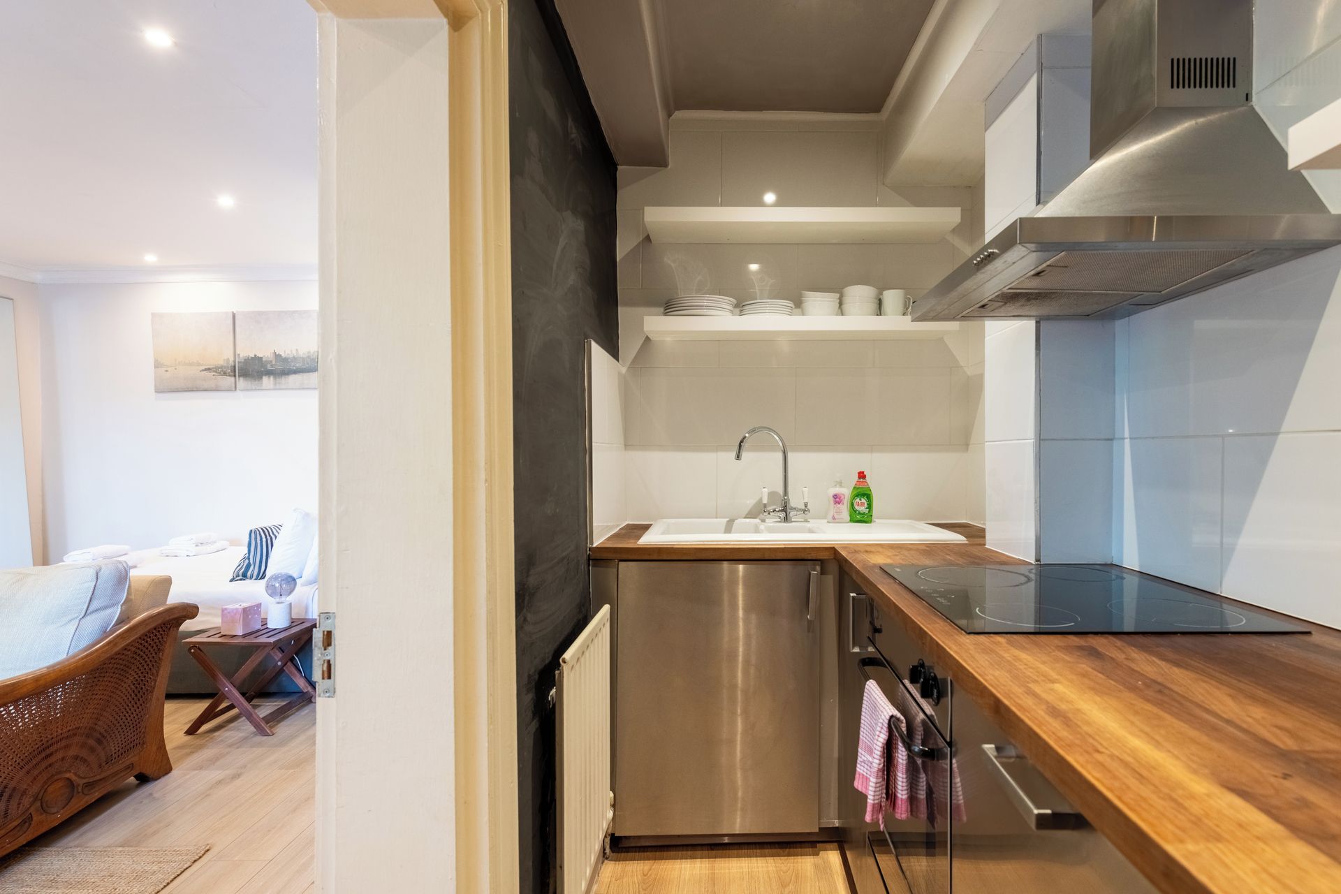 Una cocina moderna con un refrigerador de acero inoxidable, horno empotrado y encimera de madera.
