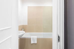 Ein Badezimmer mit einer Badewanne, einem Waschbecken und einem Spiegel.