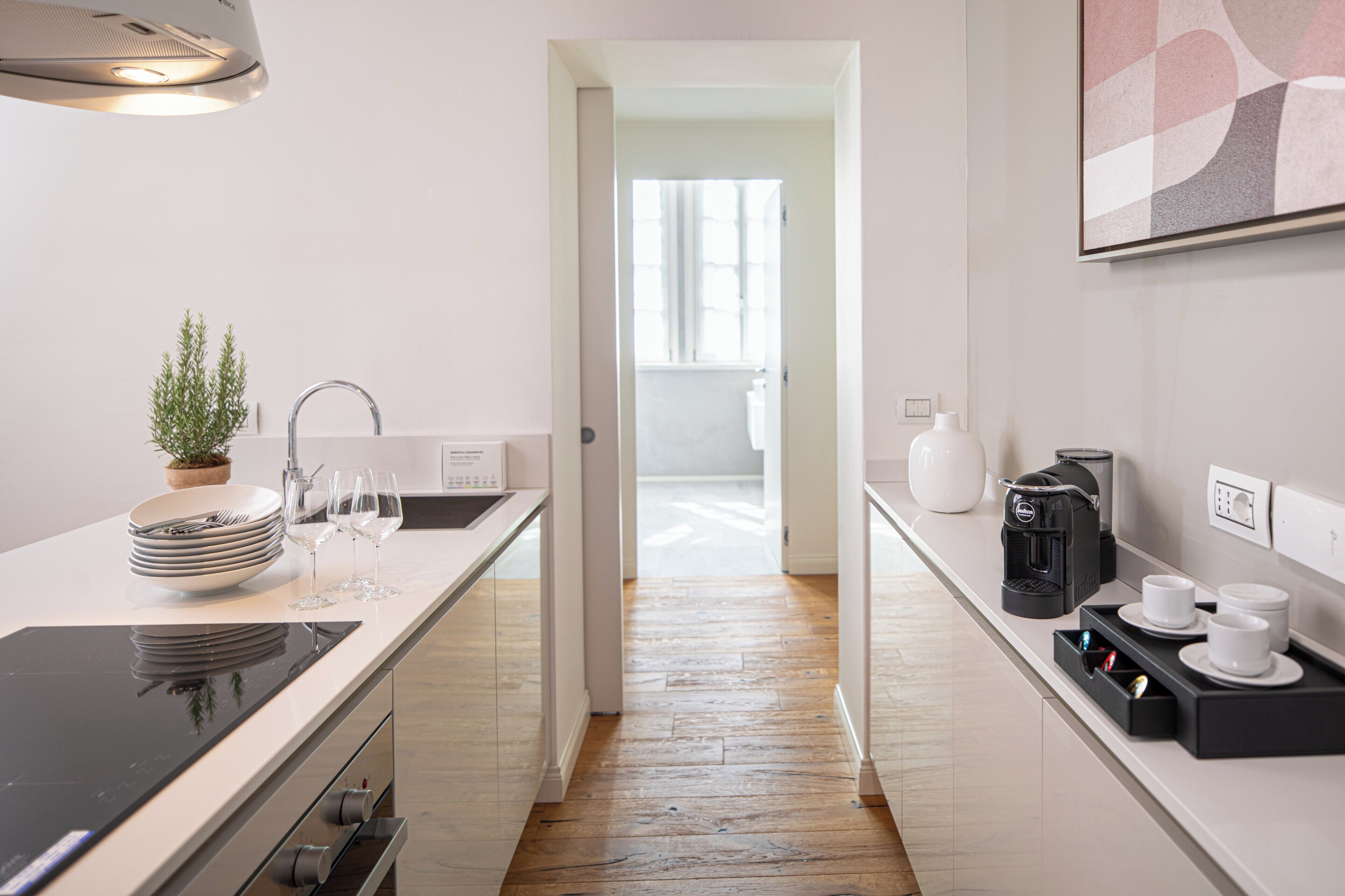 A modern kitchen with a central island, a coffee machine, and a view into the dining area.