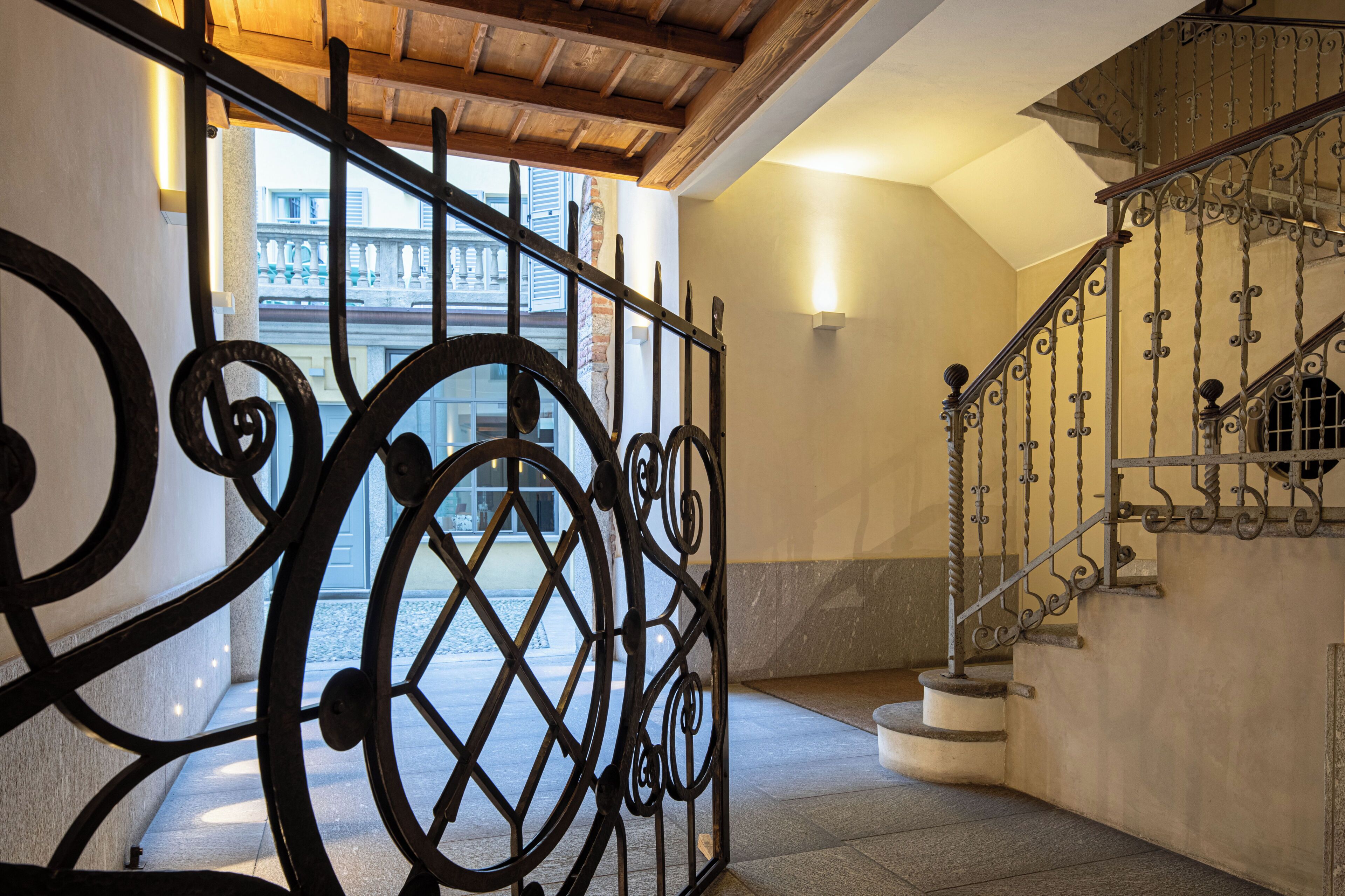 A staircase with ornate metal railings and a wooden ceiling.