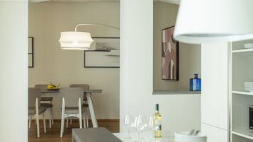 A modern dining area with a table, chairs, and a hanging light fixture.
